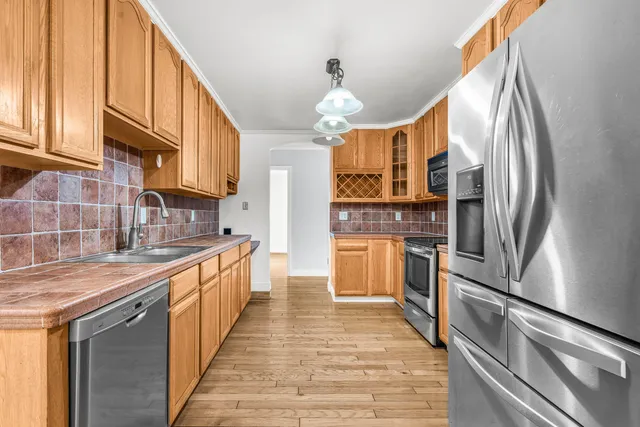 a kitchen with stainless steel appliances a refrigerator sink and cabinets
