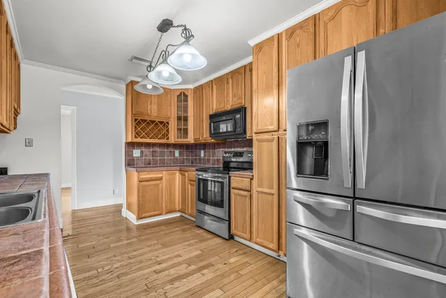 a kitchen with granite countertop stainless steel appliances and wooden floor