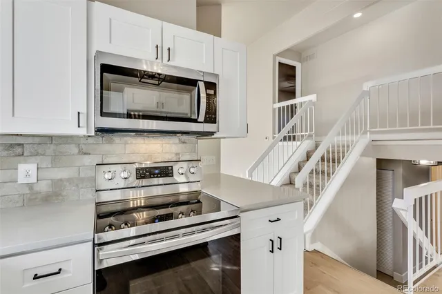 a kitchen with cabinets and steel appliances