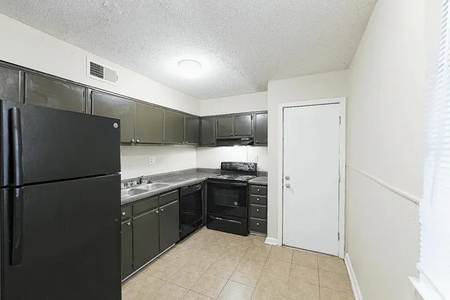 a kitchen with stainless steel appliances granite countertop a refrigerator and a stove