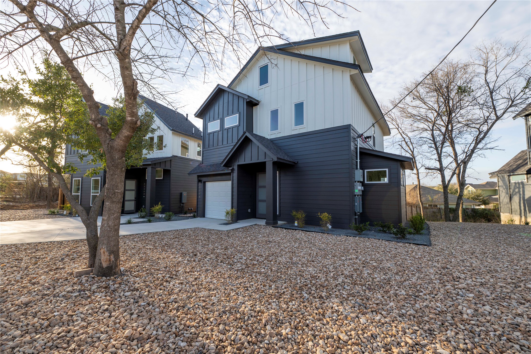 2220 Yellow Jacket Lane, Unit 1 Austin, TX 78741 - Photo 5 of 35 Modern townhome boasts sleek siding, a compact garage, and a low-maintenance gravel yard.
