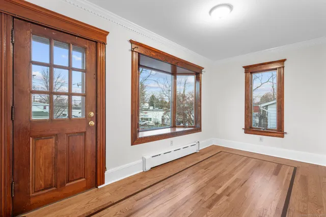 an empty room with wooden floor and windows