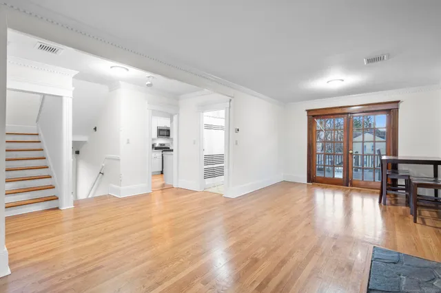 a view of empty room with wooden floor and floor to ceiling window