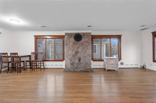 a view of empty room with wooden floor and fireplace