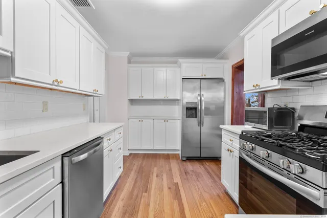 a kitchen with stainless steel appliances a refrigerator stove and microwave
