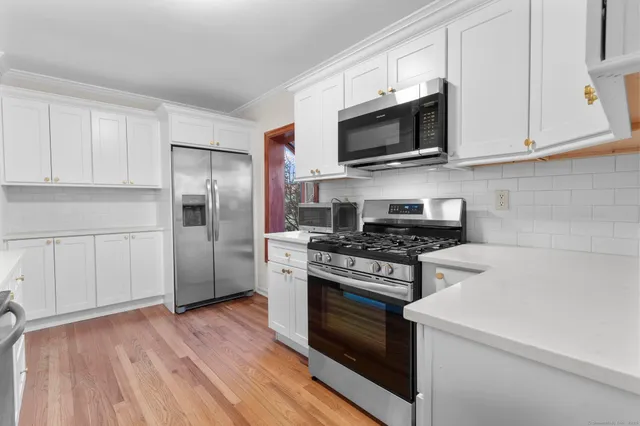 a kitchen with stainless steel appliances granite countertop a stove a refrigerator and a microwave