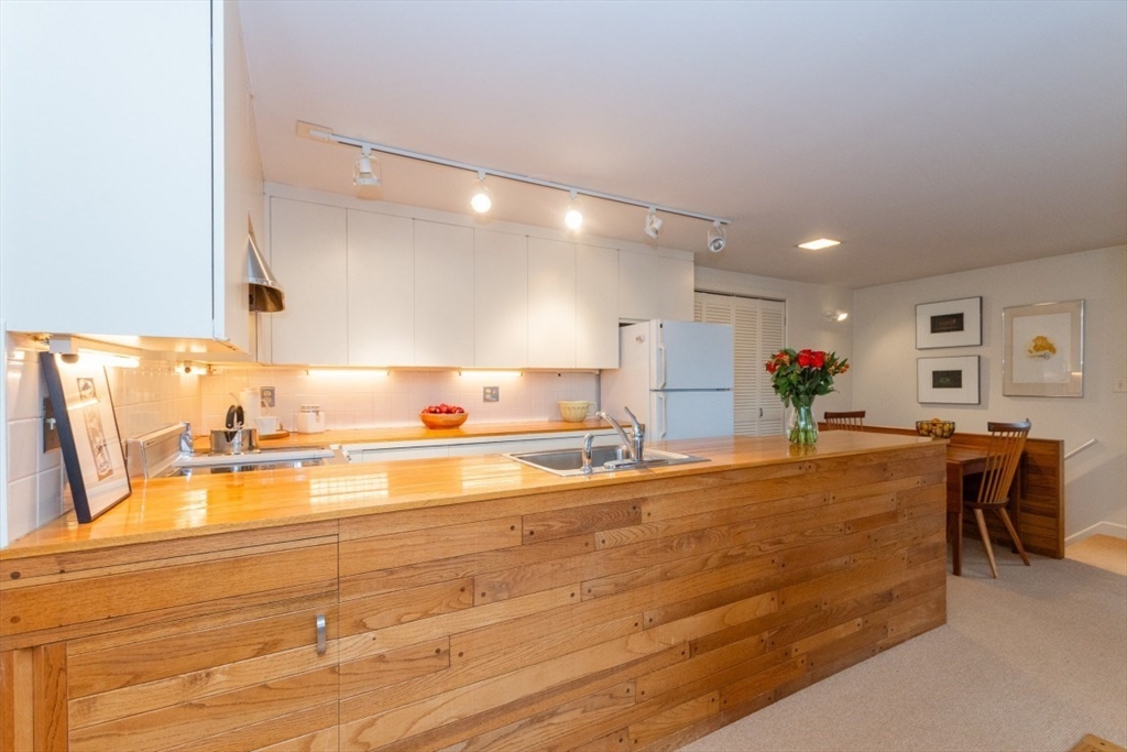 73 Valentine Street Newton, MA 02465 - Photo 7 of 26 a view of a kitchen with kitchen island white cabinets and stainless steel appliances