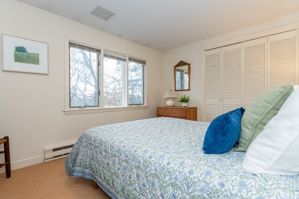 73 Valentine Street Newton, MA 02465 - Photo 9 of 26 a bedroom with a bed lamp and window