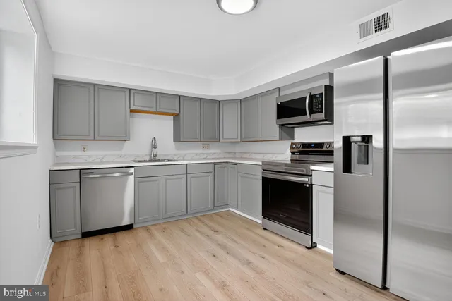 a kitchen with a sink appliances and cabinets