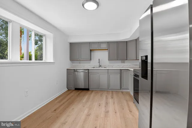 a kitchen with a sink window and stainless steel appliances