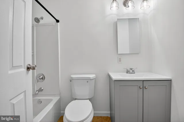 a bathroom with a toilet a sink and mirror