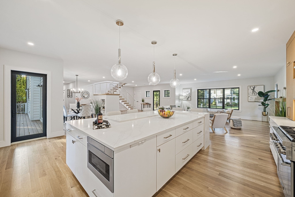 7 Ashcroft Road Sharon, MA 02067 - Photo 4 of 36 a view of a kitchen with kitchen island a stove a sink a refrigerator and a dining table with wooden floor