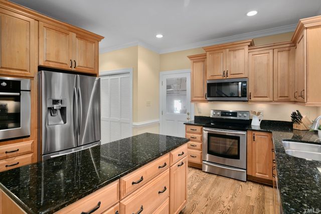 a kitchen with granite countertop a refrigerator stove and microwave