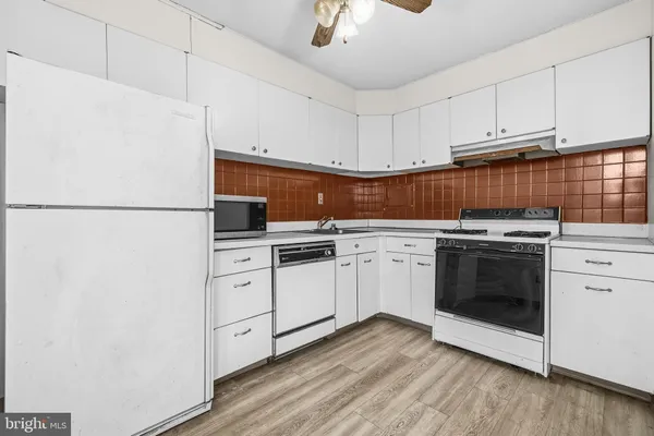 a kitchen with white cabinets and white appliances