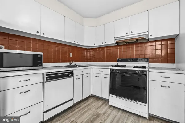 a kitchen with white cabinets stainless steel appliances and sink