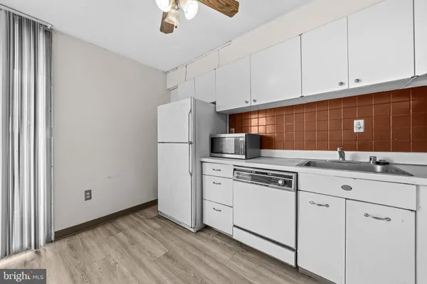 a kitchen with appliances a sink and cabinets