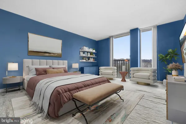 a bedroom with a large bed couch and a potted plant