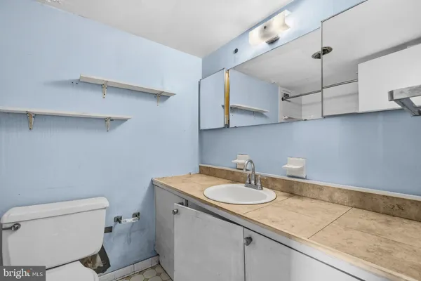 a bathroom with a sink toilet vanity and granite