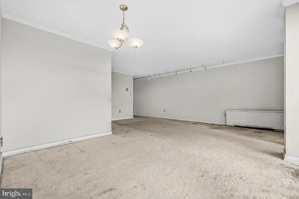 a view of an empty room with a chandelier fan