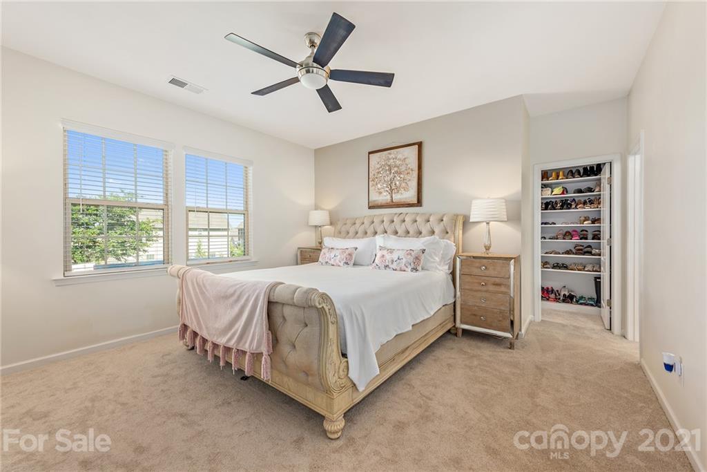 3026 Oakmere Road Waxhaw, NC 28173 - Photo 11 of 27 a spacious bedroom with a bed a window and a chandelier