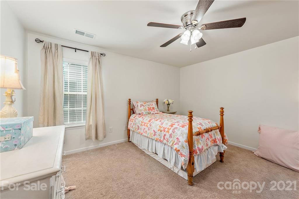 3026 Oakmere Road Waxhaw, NC 28173 - Photo 19 of 27 a bedroom with a bed and a chandelier