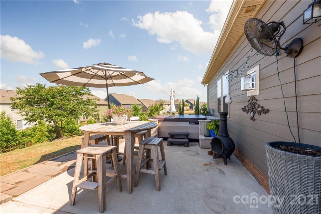 3026 Oakmere Road Waxhaw, NC 28173 - Photo 26 of 27 a view of a patio with table and chairs under an umbrella