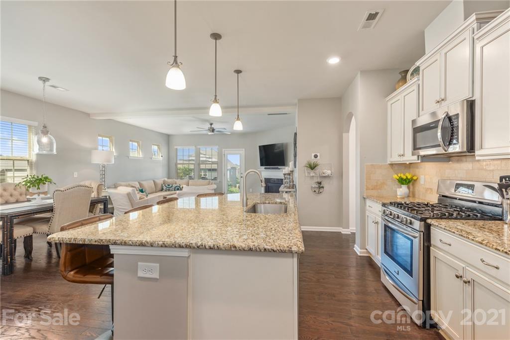 3026 Oakmere Road Waxhaw, NC 28173 - Photo 9 of 27 a large kitchen with granite countertop a sink stove and refrigerator
