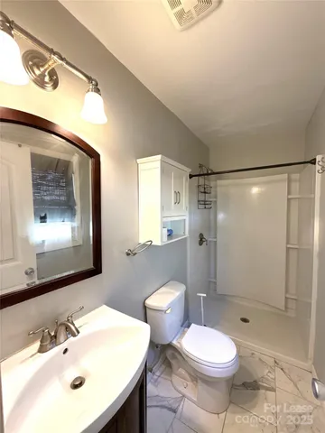 a bathroom with a sink toilet a mirror and shower