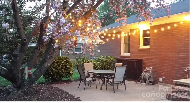 a view of a patio with a table and chairs and potted plants
