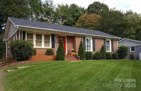 a front view of a house with a yard and green space