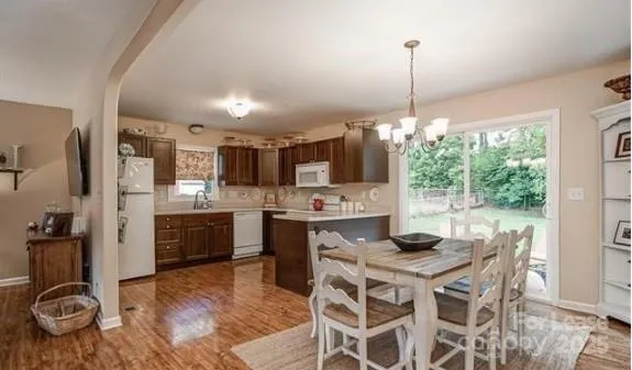 a kitchen with stainless steel appliances kitchen island granite countertop a stove and white cabinets
