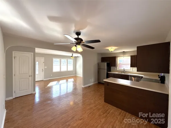 a view of a livingroom with furniture ceiling fan and wooden floor