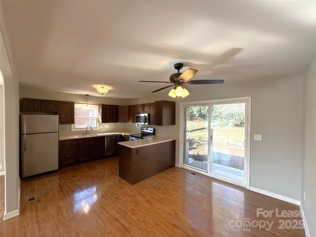 a large kitchen with a window and stainless steel appliances