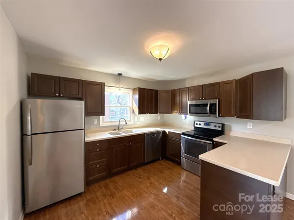 a kitchen with stainless steel appliances granite countertop a refrigerator sink and stove