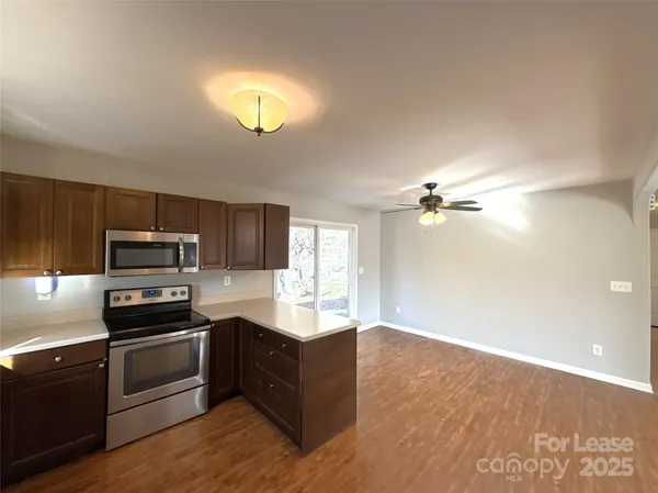 a kitchen with granite countertop a stove a sink and a refrigerator