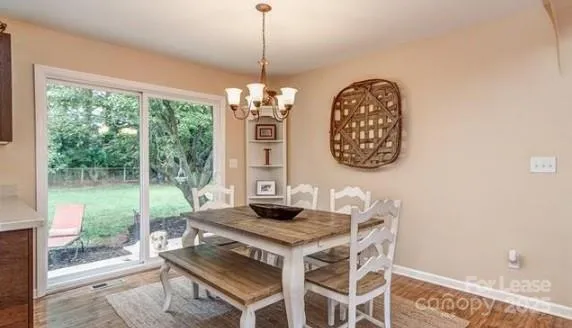 a view of a dining room with furniture wooden floor and a chandelier