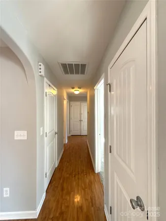 a view of a hallway with wooden floor and staircase