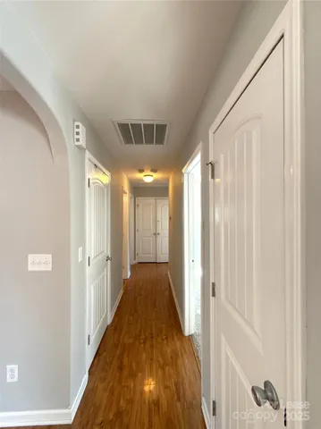 a view of a hallway with wooden floor and staircase