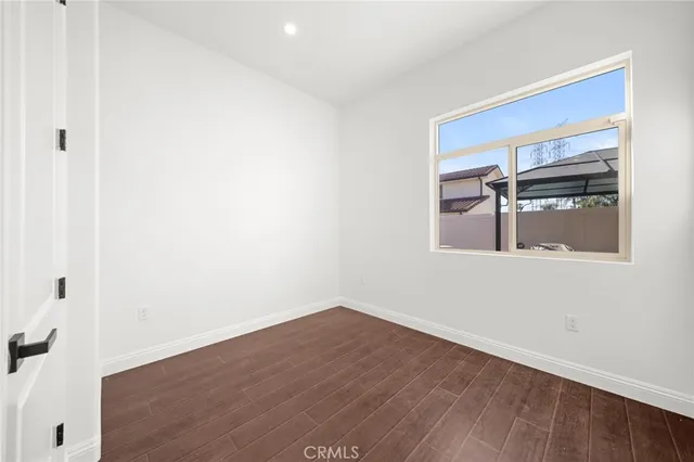 a view of a small space with wooden floor and a window