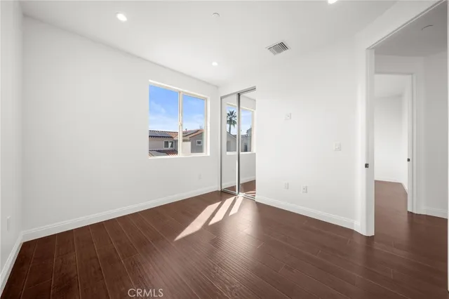 a view of a big room with wooden floor and windows