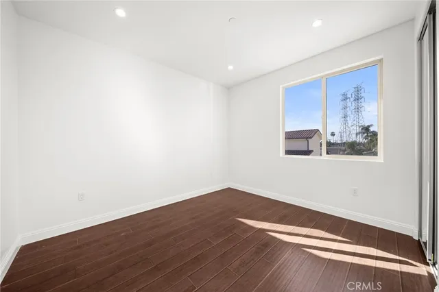 an empty room with wooden floor and window
