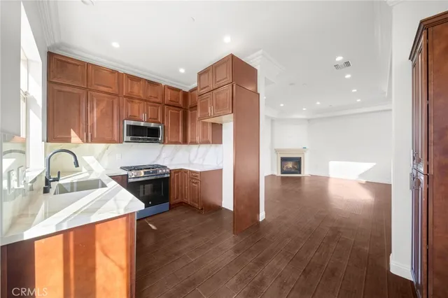 a kitchen with stainless steel appliances granite countertop a sink stove refrigerator and cabinets