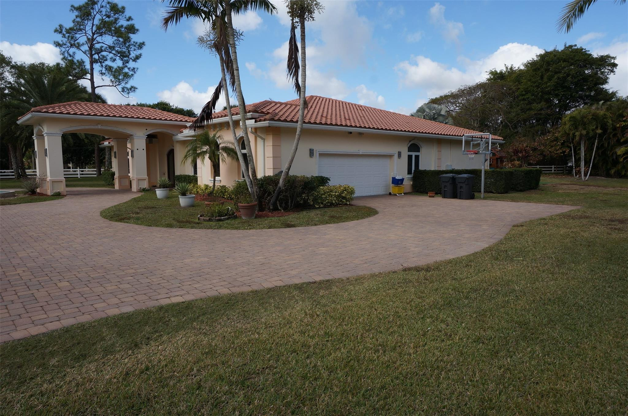 650 East Rambling Drive Wellington, FL 33414 - Photo 2 of 75 a front view of a house with garden