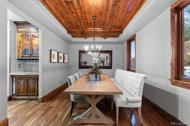 a dining room with furniture a chandelier and wooden floor
