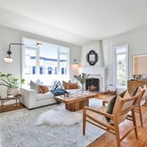 a living room with fireplace furniture and a large window