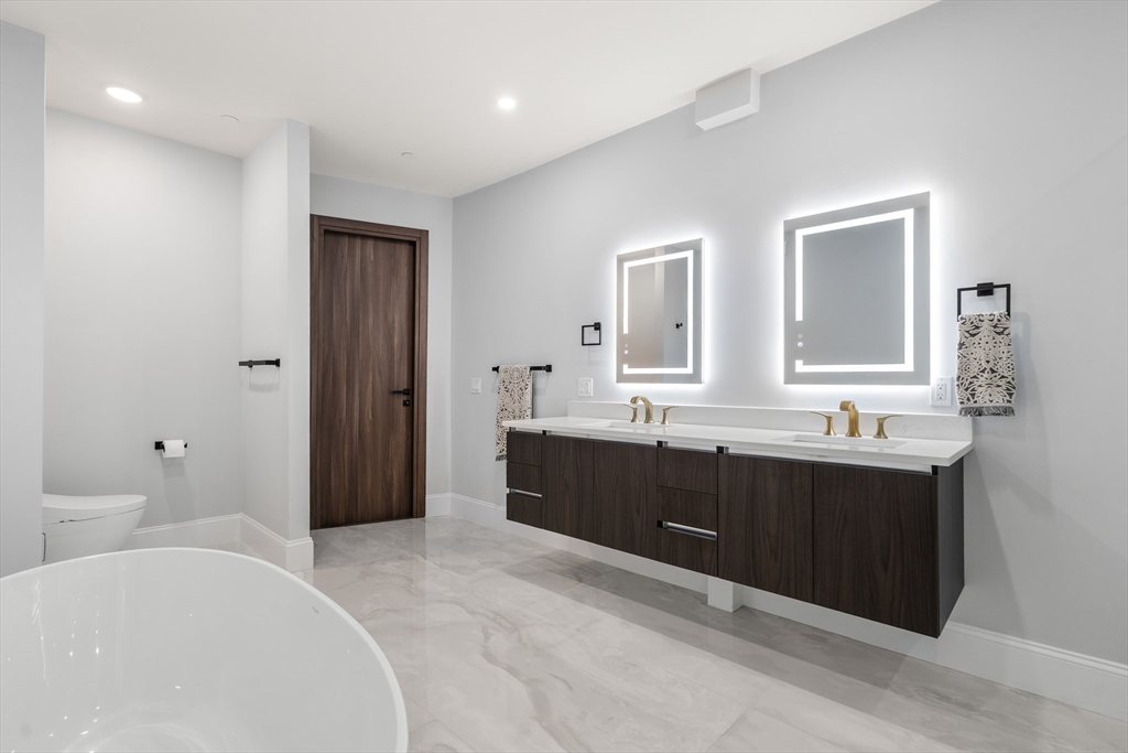 32 Pearl Street, Unit 4 Boston, MA 02125 - Photo 25 of 35 a spacious bathroom with a bathtub sink and mirror