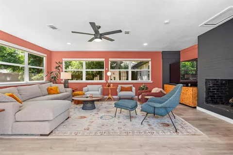 a living room with furniture a rug and a floor to ceiling window