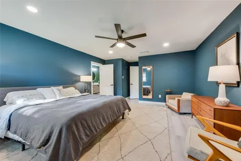 a bedroom with a large bed and a chandelier