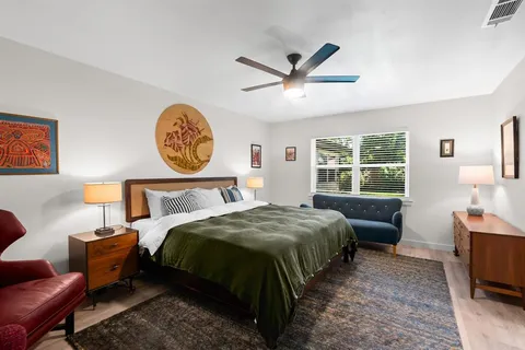 a bedroom with a bed a mirror and a window