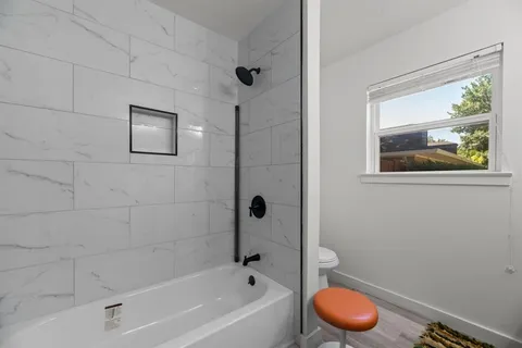 a bathroom with a granite countertop sink a toilet and bathtub